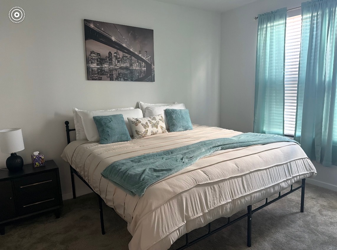 Furnished bedroom with teal accents and city skyline artwork