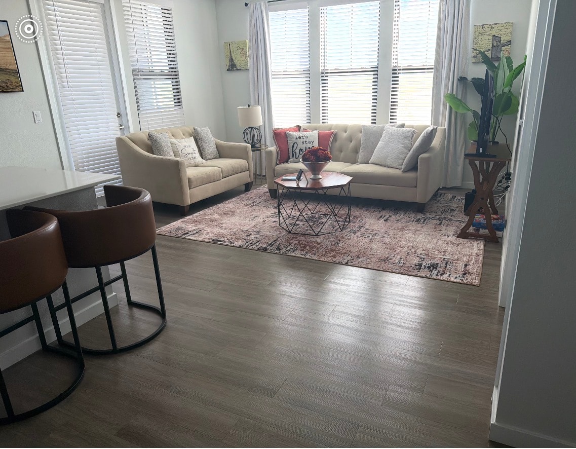 Bright living room with beige sofas and hardwood floors